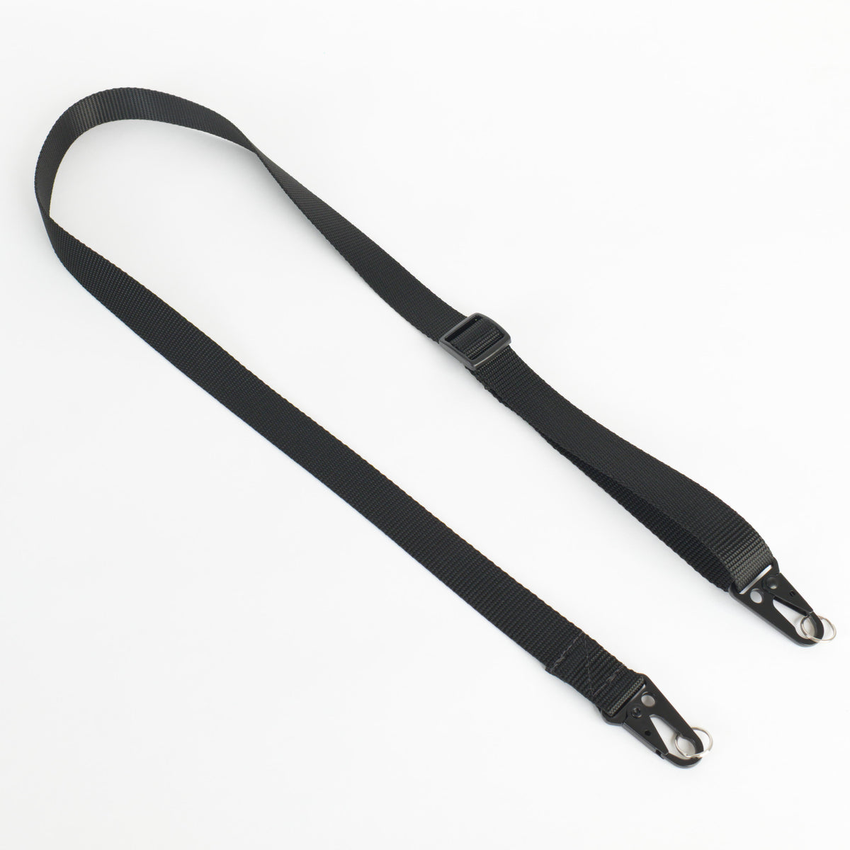 A black nylon webbing strap with black metal snap hooks on both ends and a black plastic buckle, laid out on a plain white background.