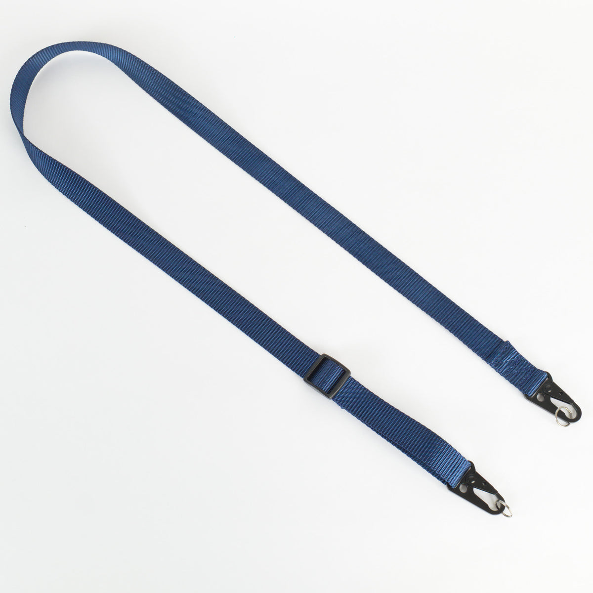 A blue nylon webbing strap with black metal snap hooks on both ends and a black plastic buckle, laid out on a plain white background.