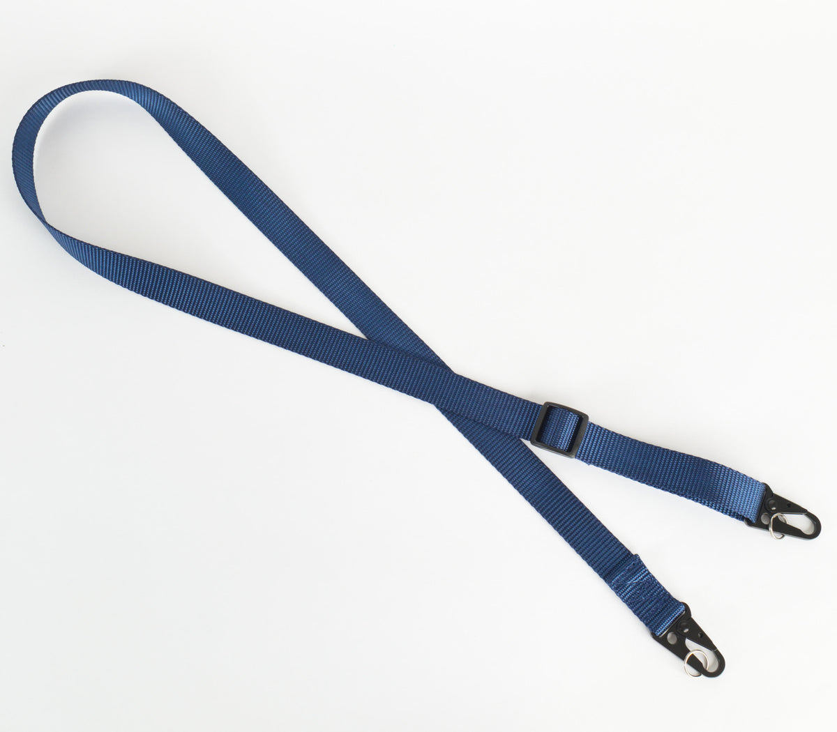 A blue nylon webbing strap with black metal snap hooks on both ends and a black plastic buckle, laid out on a plain white background.