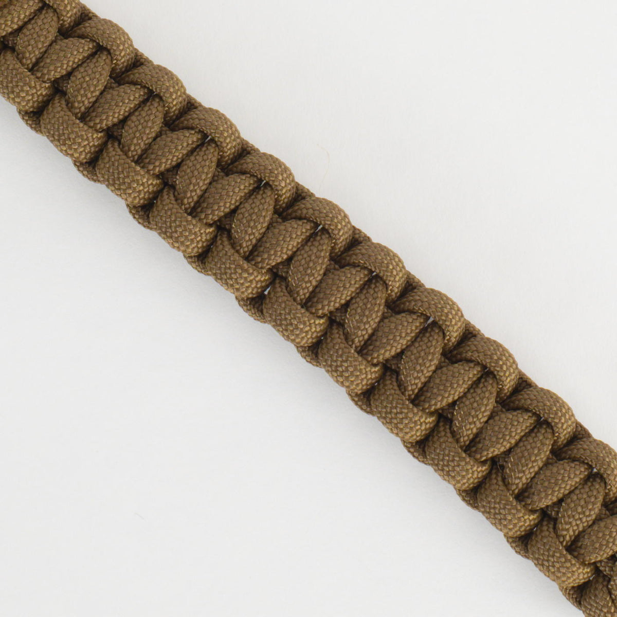 A close-up of a brown woven paracord bracelet or strap, shown diagonally against a plain white background.