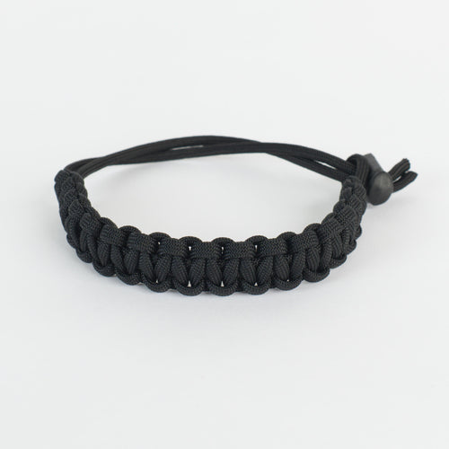 A black paracord bracelet with an adjustable sliding knot closure, shown on a clean white background.