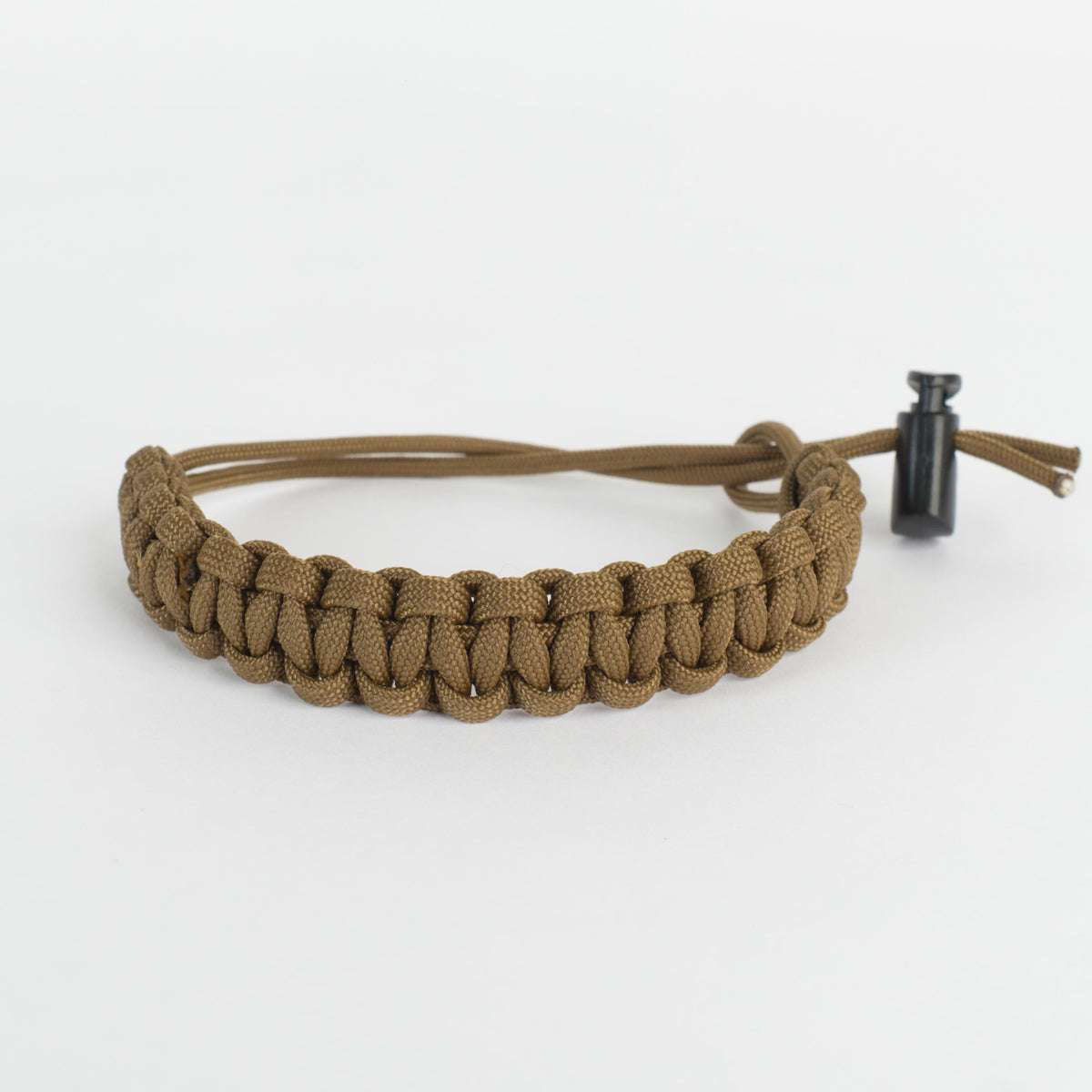A brown paracord bracelet with a black toggle clasp, photographed on a clean white background.