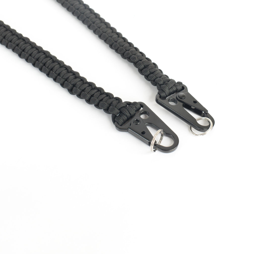 Black paracord strap with black metal clips hardware, shown on a plain white background.