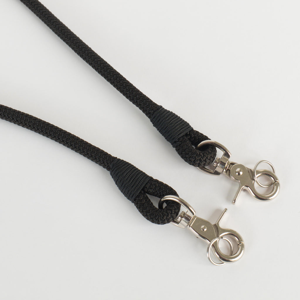 A black rope strap ends with silver metal swivel clasp and split ring hardware, shown on a clean white background.
