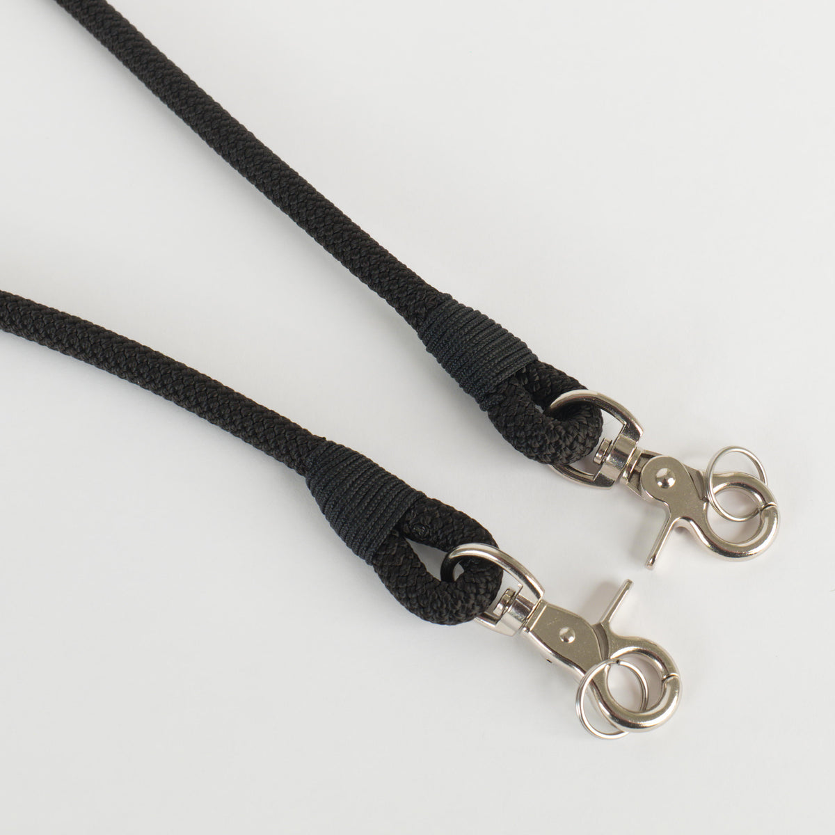 A black rope strap ends with silver metal swivel clasp and split ring hardware, shown on a clean white background.