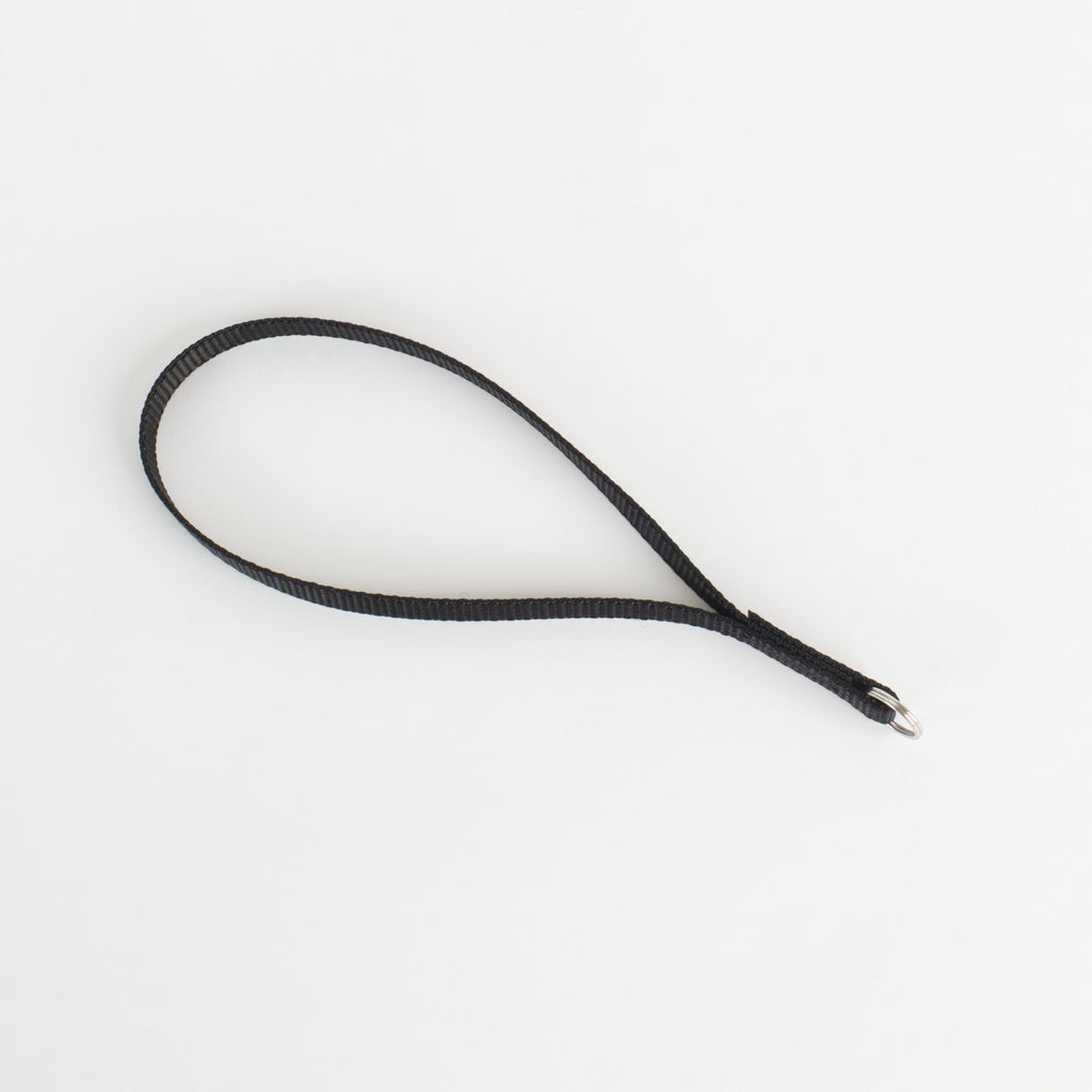 A black textured strap or loop with a silver metal split ring at one end, photographed on a clean white background.